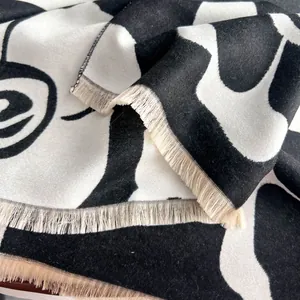 Elegant black and white camellia faux cashmere scarf with fringe edges and abstract patterns