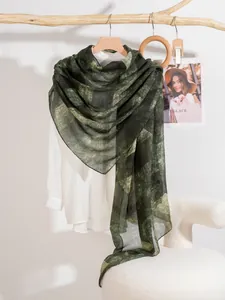 Dettaglio di un foulard sottile in seta verde a righe su una camicia bianca e ramo d'arte