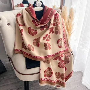 Détail du tissu doux style cachemire avec motif floral camélia et bordures à franges
