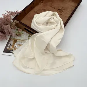 Elegante scialle plissettato crema con trama stropicciata verticale su vassoio