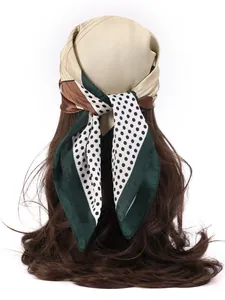 Detailed view of a satin scarf with polka dots and geometric patterns tied on hair