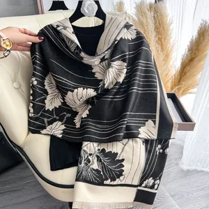 Dettaglio dello scialle jacquard floreale bianco e nero con motivo a foglie e frange