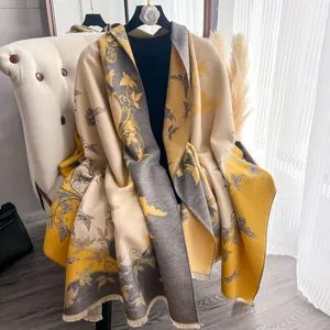 Sciarpa pashmina floreale gialla e grigia con frange su poltrona vintage