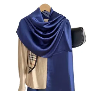 Scialle in raso blu scuro su camicia beige con tasca a quadri per protezione solare