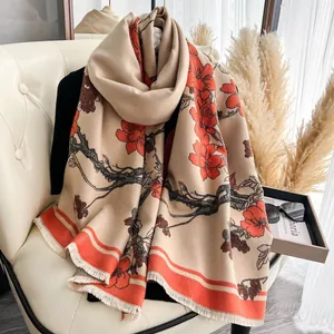 Dettaglio di sciarpa in finto cashmere beige con elegante motivo floreale rosso