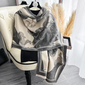 Dettaglio del motivo jacquard equestre e frange sulla morbida sciarpa in cashmere