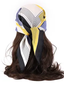 Detailed styling of geometric printed silk scarf tied on long wavy hair in close-up shot