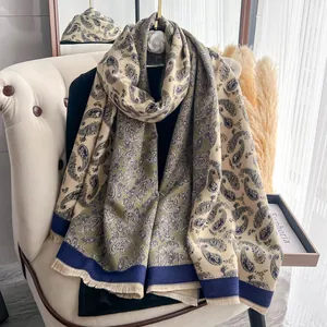 Dettaglio di una morbida sciarpa paisley con frange drappeggiata su una sedia