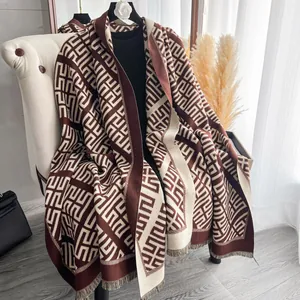 Dettaglio della sciarpa in finto cashmere con motivo greco geometrico e frange morbide