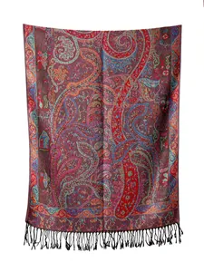 Dettaglio dello scialle paisley jacquard con colori vivaci e frange di nappe nere