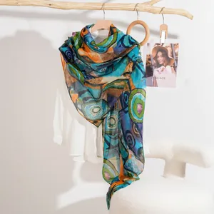 Fashionable silk shawl with abstract colorful patterns draped over a white blouse