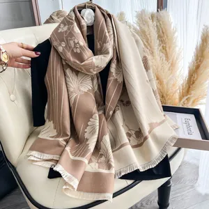 Dettaglio scialle jacquard floreale con bordi a frange e trama a maglia bicolore beige