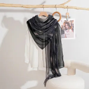 Sciarpa leggera da donna con righe sfumate grigie e nere abbinata a camicia bianca