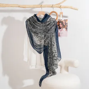Floral print lightweight scarf in navy and grey styled on a white shirt