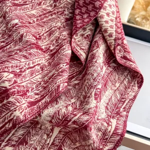 Dettaglio della trama geometrica e dei motivi a piuma sulla sciarpa di cashmere