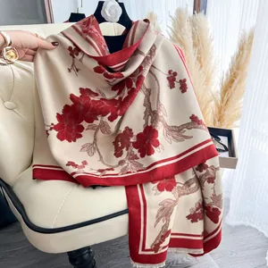 Dettaglio dello scialle floreale in cashmere sintetico drappeggiato su sedia beige