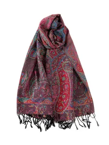 Dettaglio del tessuto jacquard paisley rosso con trama morbida e nappe nere eleganti