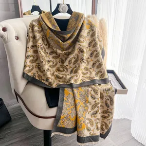 Dettaglio del motivo paisley vintage su una sciarpa invernale spessa con bordi a frange