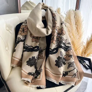 Dettaglio della sciarpa effetto cashmere con motivi floreali e bordi a frange