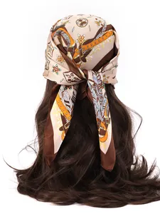 Detail of bohemian floral print silk scarf tied on brown wavy hair showing retro pattern