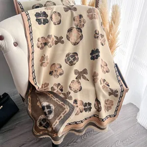 Vue détaillée du motif floral double face et des franges sur un châle en cachemire doux