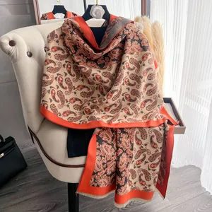 Dettaglio di una scialle caldo con motivo paisley vintage drappeggiato sulla poltrona