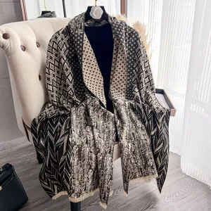 Elegante scialle pashmina con motivi geometrici e frange su una sedia bianca