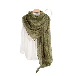 Lightweight olive green floral silk scarf styled as a shawl over a white shirt