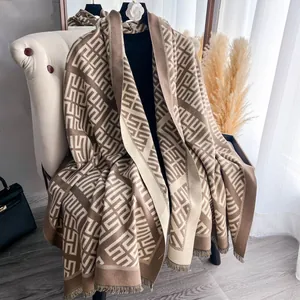 Dettaglio dello scialle in maglia a motivi geometrici con eleganti frange