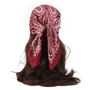 Burgundy paisley silk-like bandana tied on long curly hair with a satin finish look