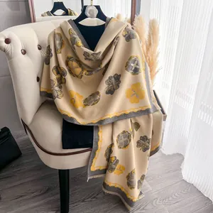 Détail d'un châle en imitation cachemire avec motif floral jaune et bords à franges