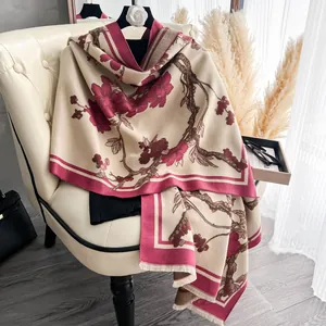 Dettaglio della sciarpa in finto cashmere con fiori rosso vino e frange