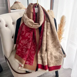Detail of winter scarf featuring paisley dot floral patterns and soft fringe edges