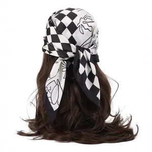 Fashionable silk-like scarf with black and white checkerboard pattern tied on long hair