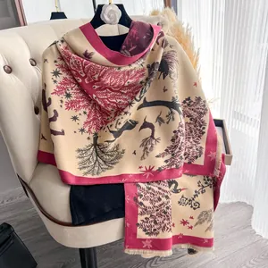 Dettaglio della sciarpa in finto cashmere con motivo foresta e cervo e bordi a frange