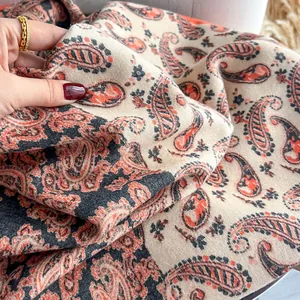 Dettaglio dello scialle con stampa paisley che mostra la trama fine e il drappeggio