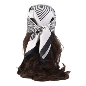 Silky black and white geometric pattern scarf worn as a stylish headband for women