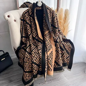 Dettaglio di una sciarpa spessa in finta cashmere con motivo geometrico e frange