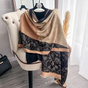 Close-up of winter floral scarf with dot patterns and tassel hem in earthy tones
