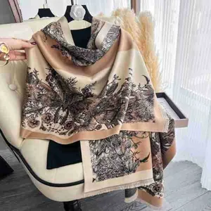Detail of vintage floral scarf with bird prints and tassels draped over a leather chair