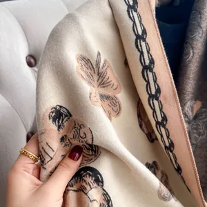 Détail d'une écharpe en cachemire synthétique avec motif d'ours et bordure soignée