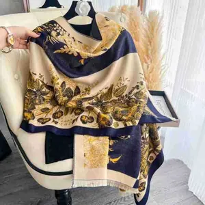 Detail of floral patterns and fringe on navy blue and gold thick winter shawl