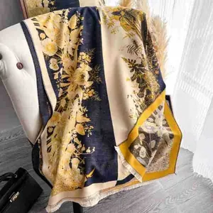 Detailed view of elegant floral scarf with fringe trim draped on a white armchair