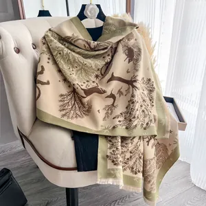Dettaglio dello scialle in finto cashmere con jacquard foresta e renne e frange fini