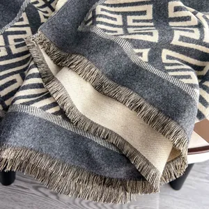 Dettaglio di sciarpa jacquard grigia e beige con frange e morbida trama tipo cashmere
