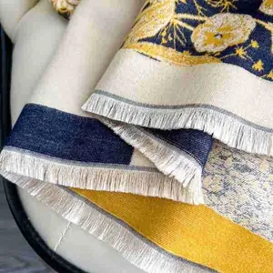 Detailed close-up of floral jacquard pattern and soft tassel edges on a thick scarf