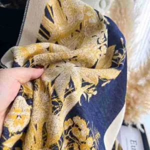 Detail of vintage navy and yellow floral thick knit scarf with soft jacquard texture