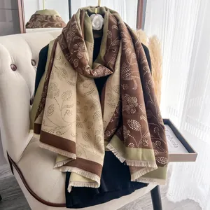 Detail of soft winter shawl featuring vintage floral dot patterns and elegant tassel trim
