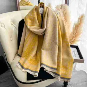 Dettaglio di scialle giallo effetto cashmere con jacquard damascato vintage e frange corte