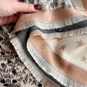 Dettaglio della morbida sciarpa simil-cashmere con motivi a palma e frange fini